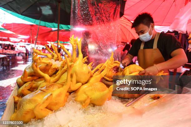 Worker prepares chicken meat for sell at Khlong Toei market in Bangkok. The Department of Livestock Development is keeping a close watch on the...