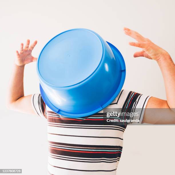 man covering his head with a plastic bucket - wash bowl stock pictures, royalty-free photos & images