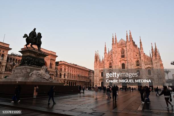 Picture taken on January 18, 2022 shows people strolling in front of the Duomo di Milano on Piazza del Duomo in central Milan.