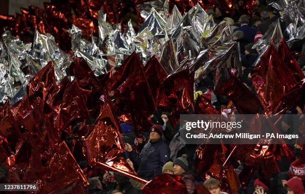 Aberdeen fans wave flags during the cinch Premiership match at Pittodrie Stadium, Aberdeen. Picture date: Tuesday January 18, 2022.