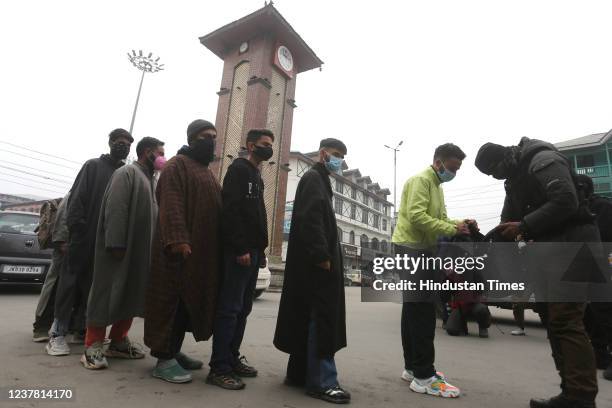 Policeman checks peoples belongings during a search operation at Lal Chowk area on January 18, 2022 in Srinagar, India.