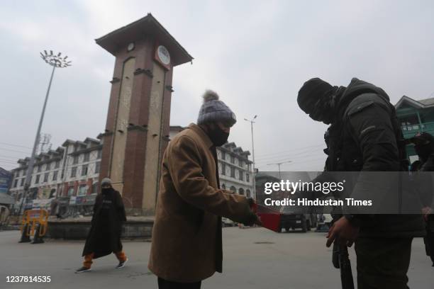 Policeman checks peoples belongings during a search operation at Lal Chowk area on January 18, 2022 in Srinagar, India.