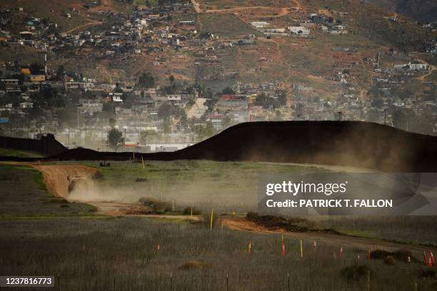 Vehicle drives along the US-Mexico border wall, a portion which remains uncompleted, near Otay Mesa between San Diego and Tijuana on January 12, 2022...