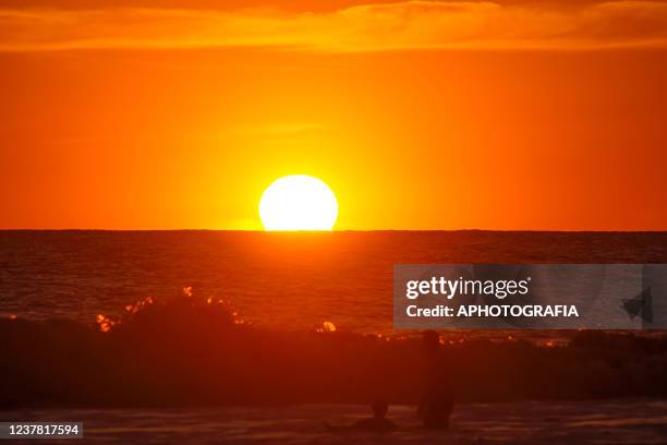 People enjoy a sunset at the San Blas beach on January 18, 2022 in La Libertad, El Salvador.