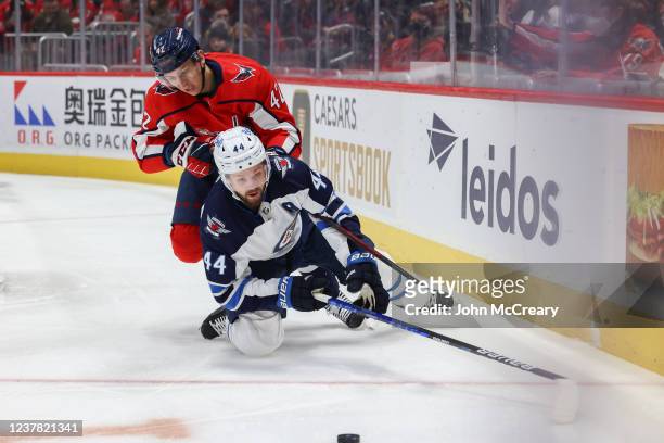 Martin Fehervary of the Washington Capitals knocks down Josh Morrissey of the Winnipeg Jets during a game at Capital One Arena on January 18, 2022 in...