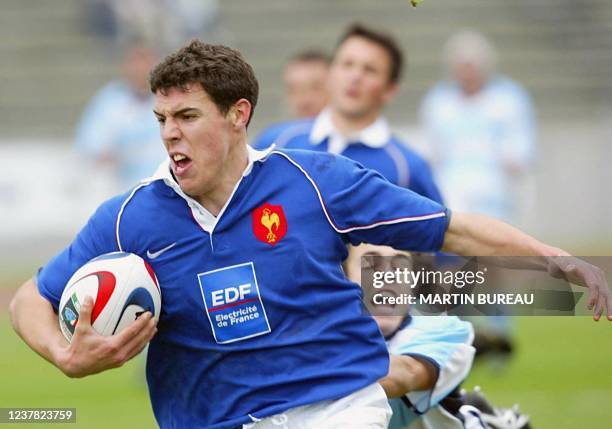 Arrière français Jean-Baptiste Peyras échappe au placage d'un joueur argentin le 20 avril 2003 à Bondoufle, lors du match pour la troisième place de...