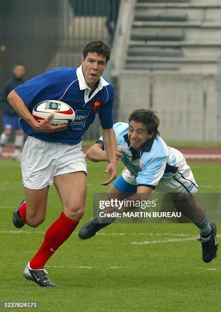 Arrière français Jean-Baptiste Peyras échappe au placage d'un joueur argentin le 20 avril 2003 à Bondoufle, lors du match pour la troisième place de...