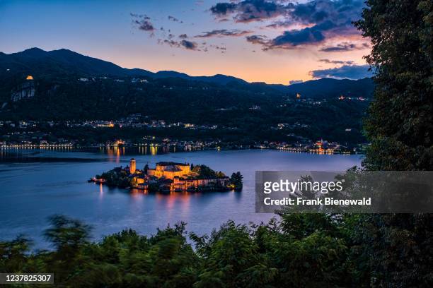 Aerial view from Sacro Monte on St. Julius Island with Basilica di San Giulio in the middle of Lake Orta, surrounding mountains in the distance at...