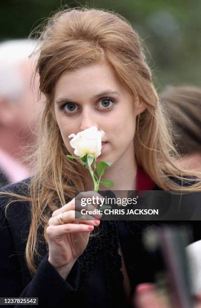 Britain's Princess Beatrice smells a rose she was presented with as she visits the Monaco Garden at the Chelsea Flower Show press and VIP day in...