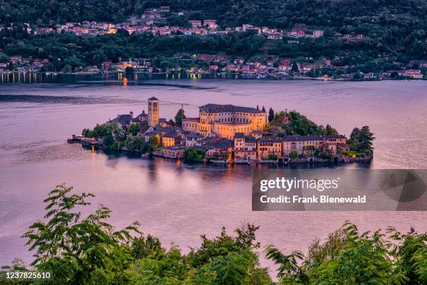 Aerial view from Sacro Monte on St. Julius Island with Basilica di San Giulio in the middle of Lake Orta, illuminated at night.