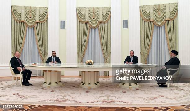 Russian President Vladimir Putin speaks with Iranian President Ebrahim Raisi during their meeting in Moscow on January 19, 2022.