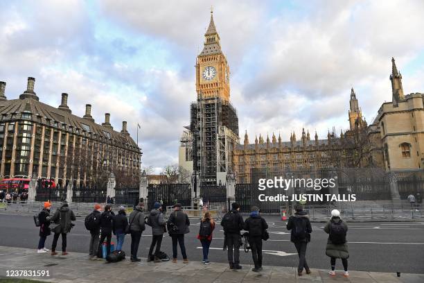 Members of the media wait opposite the exit to the House of Commons, for Britain's Prime Minister Boris Johnson to leave, backdropped by the...