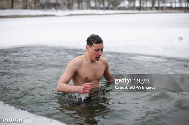 Man takes a bath in cold water during the celebration of Epiphany. People believe that water has special healing properties and can be used to treat...