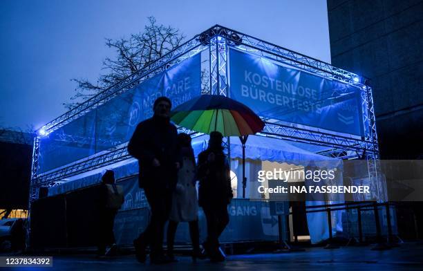 Pedestrians walk past a free rapid testing centre in the city of Duesseldorf, western Germany on January 19 during the ongoing coronavirus pandemic....