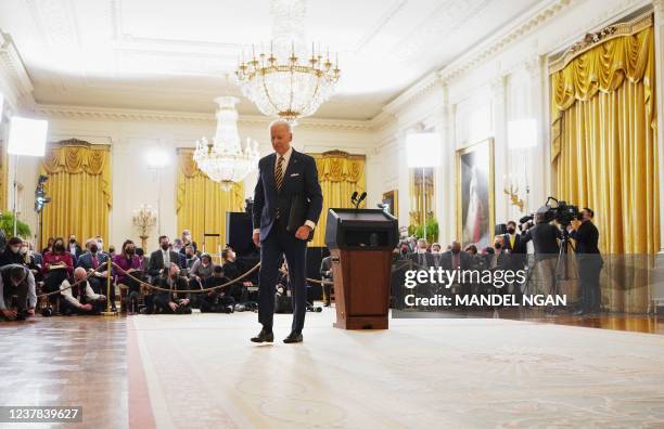 President Joe Biden departs after a press conference on the eve of his first year in office, from the East Room of the White House in Washington, DC...