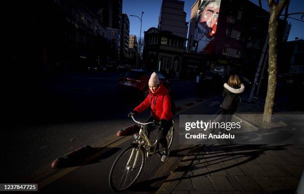 Woman rides a bicycle in Tirana, Albania on January 17, 2022.