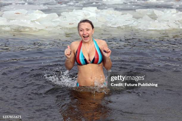 Woman bathes in the Dnipro River on Epiphany in Hidropark, Kyiv, capital of Ukraine.