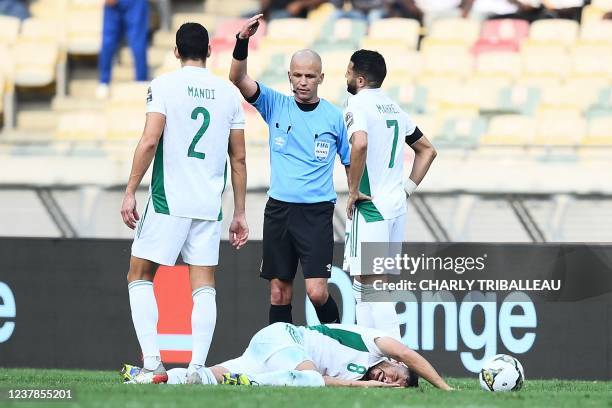 Algeria's forward Youcef Belaili reacts after being injured as Algeria's defender Aissa Mandi , South African referee Victor Gomes , and Algeria's...