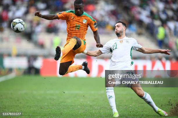 Ivory Coast's forward Nicolas Pepe is challenged by Algeria's defender Ramy Bensebaini during the Group E Africa Cup of Nations 2021 football match...