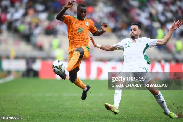 Ivory Coast's forward Nicolas Pepe is challenged by Algeria's defender Ramy Bensebaini during the Group E Africa Cup of Nations 2021 football match...