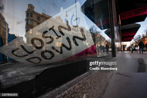 Shopper walks past a closing down sign in the window of the now closed House of Fraser Ltd. Department store on Oxford Street in central London,...