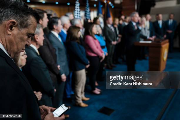 Rep. Darrell Issa checks his phone as House Minority Leader Kevin McCarthy speaks during a House Republican Conference news conference as members...
