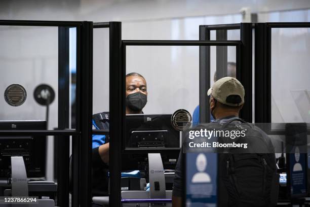 Transportation Security Administration agent screens a traveler at a checkpoint in terminal 2 at Raleigh-Durham International Airport in Morrisville,...