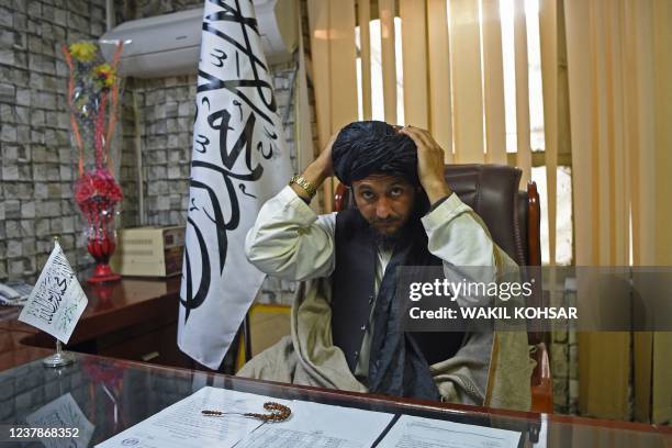 In this photograph taken on December 12 Taliban head of the Nangarhar intelligence services Dr Bashir adjusts his turban ahead of an interview with...