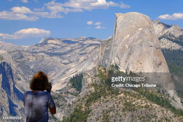 Visitor snaps photos of Half Dome from Washburn Point in Yosemite National Park on Aug. 4, 2021. The peak of Half Dome is over 8,000 feet above sea...