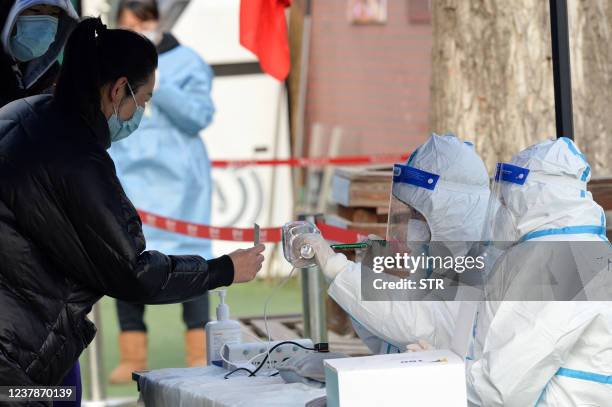 This photo taken on January 20, 2022 shows a resident preparing to undergo a nucleic acid test for the Covid-19 coronavirus in north China's Tianjin....