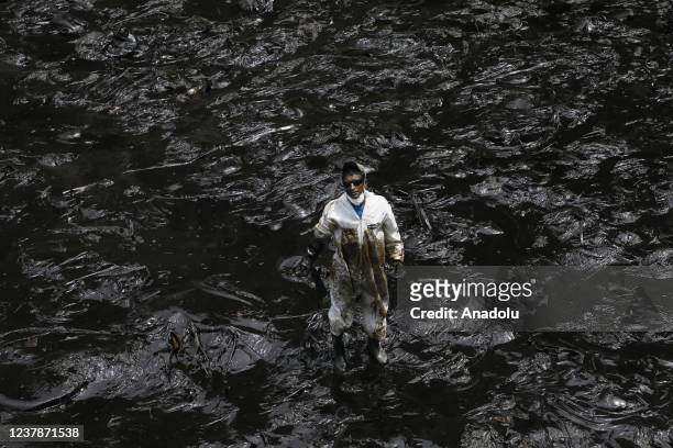 Cleaning teams work to remove oil at the shores after an oil spill in the Ventanilla Sea in the province of Callao has stained the beaches of the...