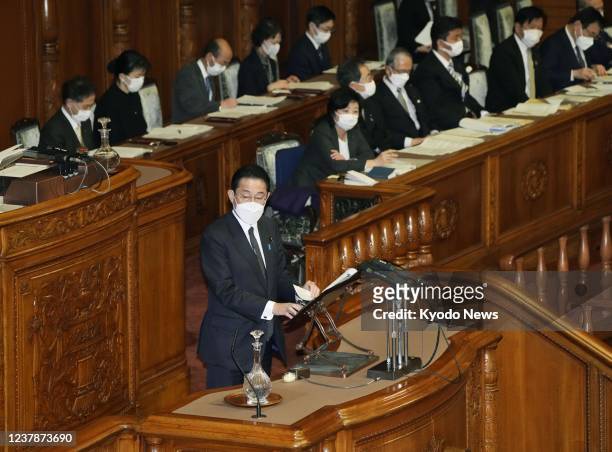 Japanese Prime Minister Fumio Kishida speaks during a House of Councillors plenary session in Tokyo on Jan. 21 wearing a face mask amid the...