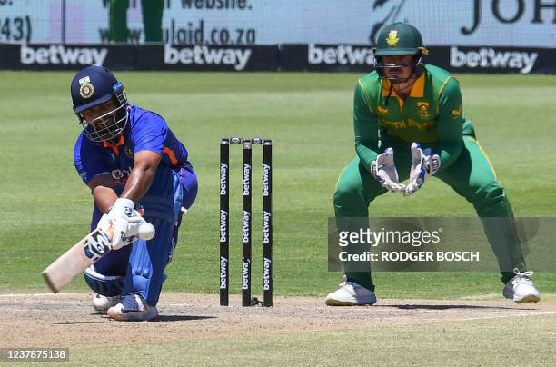 India's Rishabh Pant plays a reverse sweep shot as South Africa's wicketkeeper Quinton de Kock looks on during the second one-day international...