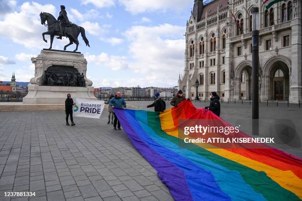 Activists deploy a 30-meter-long rainbow-colored flag in front of the Hungarian Parliament building on January 21, 2022 prior to a press conference...