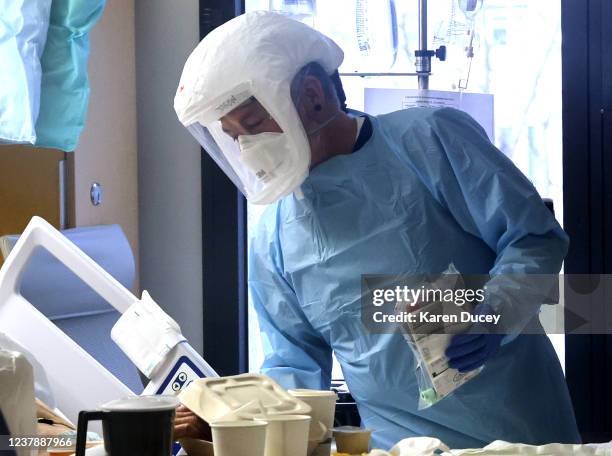Nurse Jason Doff, wearing a powered air purifying respirator called a PAPR, administers care in the acute care COVID-19 unit at the Harborview...