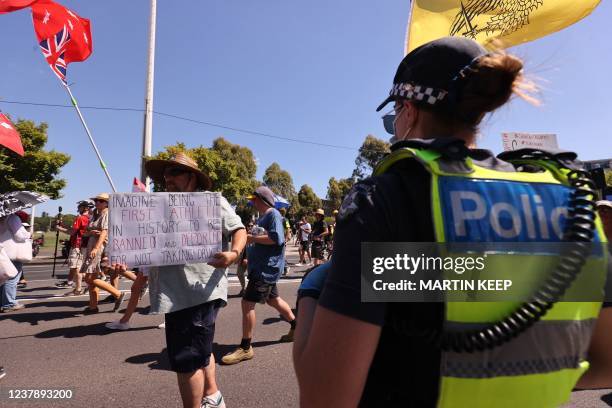 Police stand guard as people take part in a rally against Covid-19 coronavirus vaccinations, outside the main gates at the Australian Open tennis...