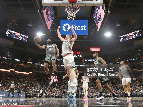 James Harden of the Brooklyn Nets shoots by Jakob Poeltl of the San Antonio Spurs in the second half at AT&T Center on January 21, 2022 in San...