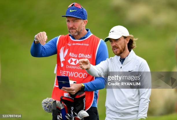 Tommy Fleetwood of England talks with his caddie at the second hole during the third round of the Abu Dhabi HSBC championship at Yas Links Golf...