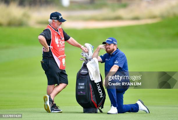 Shane Lowry of Ireland talks with his caddie at the second hole during the third round of the Abu Dhabi HSBC championship at Yas Links Golf Course,...