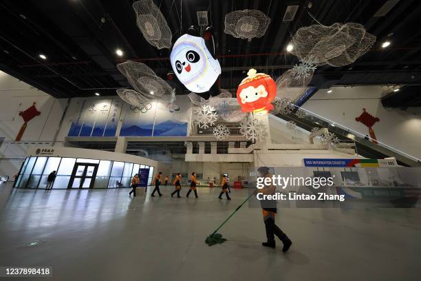 Staff members clean of the ground at the Main Media Center for the 2022 Olympic and Paralympic Winter Games on January 22, 2022 in Beijing, China....