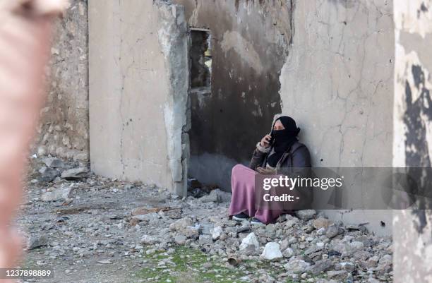 Woman talks on the phone as Syrians flee their homes in the Ghwayran neighbourhood in the northern city of Hasakeh on January 22 on the third day of...