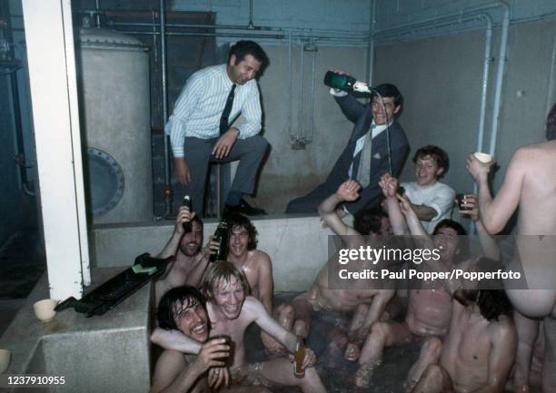 Birmingham City manager Freddie Goodwin looks on as Stan Harland pours champagne over the players who are celebrating together in the bath after...