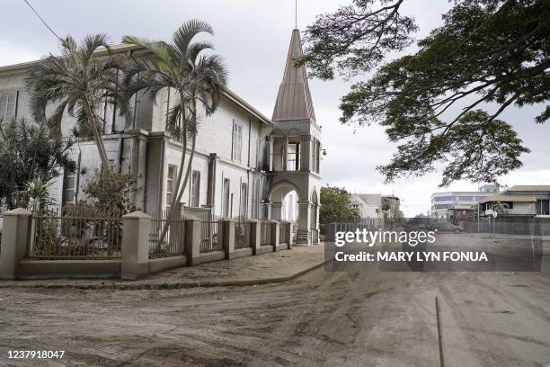 This photo taken on January 16, 2022 shows volcanic ash covering the street by the old prime ministers office in Tonga's capital Nukualofa following...