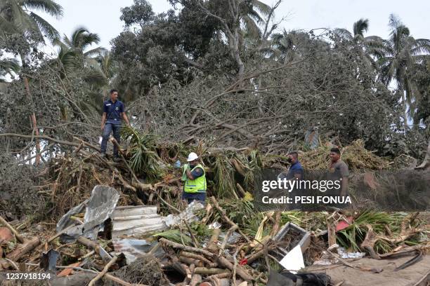 This photo taken on January 16, 2022 shows a search and rescue team looking for missing British woman Angela Glover through tsunami damage in...