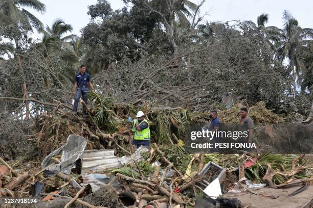This photo taken on January 16, 2022 shows a search and rescue team looking for missing British woman Angela Glover through tsunami damage in Haatafu...