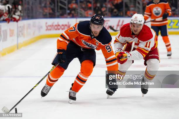 Connor McDavid of the Edmonton Oilers battles against Mikael Backlund of the Calgary Flames during the second period at Rogers Place on January 22,...