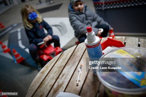 Syringe set up with the BioNTech/Pfizer vaccine dosed for children is seen on a table as children wait in queue to get vaccinated at a test and...