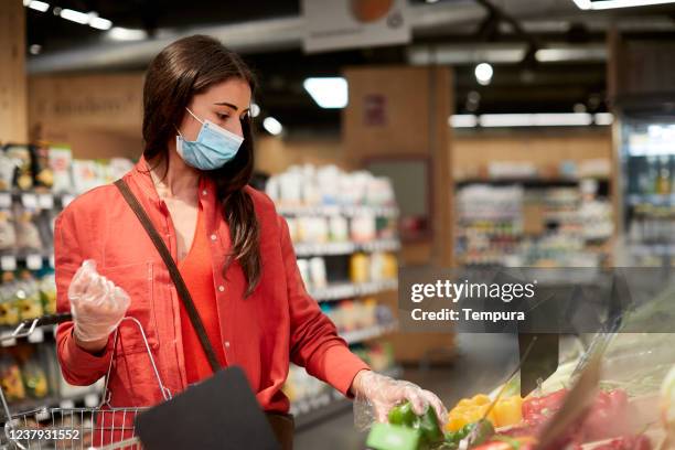 one woman choosing vegetables at the grocery shop - supermarket mask stock pictures, royalty-free photos & images