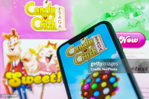 Candy Crush Saga logo displayed on a phone screen and Candy Crush website displayed in the background is seen in this illustration photo taken in...