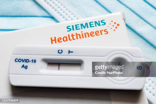 Negative result of a rapid COVID-19 antigen self-test Clinitest by Siemens Healthineers is photographed on surgical masks background for illustration...